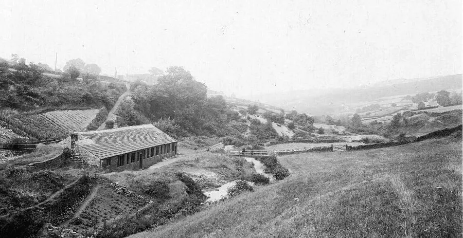 The grinding room at Wolf Wheel, probably the largest in the valley (undated). The footbridge marks the cross-valley route from Dore to Bradfield, which climbs the steep bank behind the building. Note also the cultivated land on the slopes nearby. From the RVCG collection.